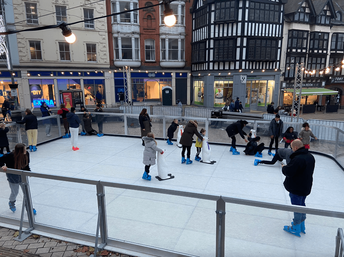 A busy ice skating rink located outside of the Arc shopping centre