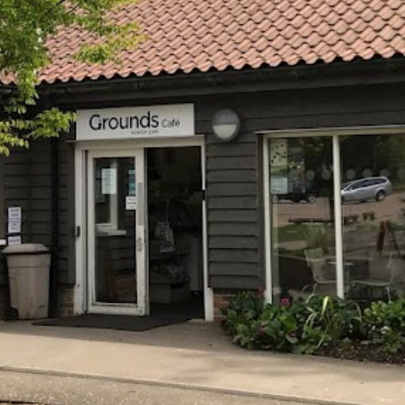 The exterior of Grounds Cafe, amongst trees and greenery.