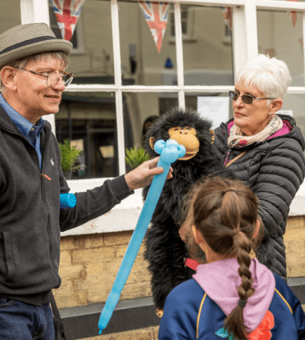 man creates balloon animals on the street of Bury St Edmunds